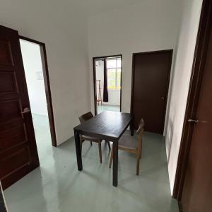 a dining room with a wooden table and chairs at Ipoh Apartment Suites in Ipoh