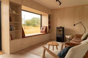 ein Wohnzimmer mit einer Couch und einem Fenster in der Unterkunft Casa Hikari - Lofoten Retreat in Vestvågøya