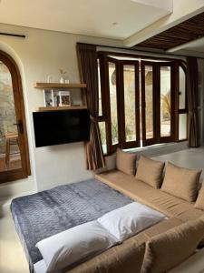 The Bora Villas في Ngaglik: أريكة كبيرة في غرفة معيشة بها نوافذ +36 صورة