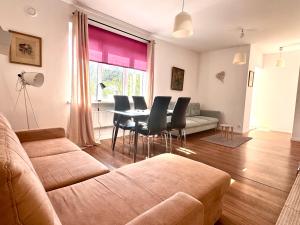 a living room with a couch and a table and chairs at Familly Apartament 3 in Międzyzdroje +4 photos