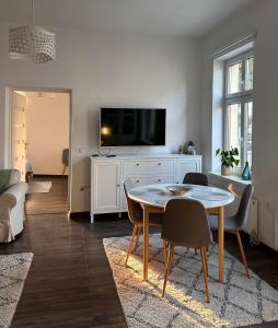 a living room with a table and a tv at Apartament w centrum miasta in Szczytno +13 photos