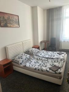 Un dormitorio con una cama y una mesa y una ventana. en Rooms v samém centru Ostravy, en Ostrava 19 fotos más