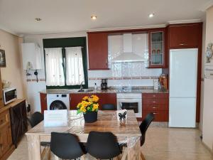 a kitchen with a table and chairs in a kitchen at Amanecer en Playa de LLás in Foz