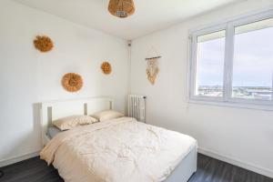 a white bedroom with a bed and a window at Pause Douceur - Cocoon lumineux in Alfortville