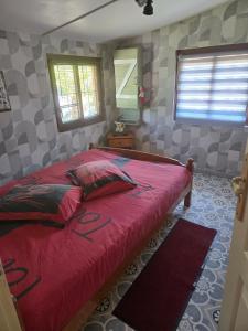 a bedroom with a red bed in a room at Chalet piscine chauffée et couverte in Brimeux +53 photos