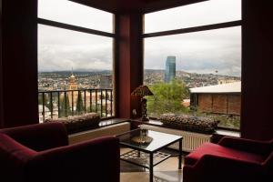 a room with a large window with a view of a city at Boutique Hotel "Andza Tiflis" in Tbilisi City