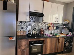a kitchen with a refrigerator and a stove top oven at Appartement tamaris les crêtes in Casablanca