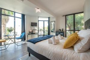 a bedroom with a large white bed and large windows at L'Adriana 102 - Clim & wifi - Proximité mer in Carry-le-Rouet