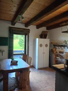 a kitchen with a large table and a refrigerator at Domek Przyjacielówka Miejsce Ciszy Czarna Góra Sienna Janowa Góra in Stronie Śląskie +51 photos