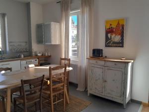 a kitchen and dining room with a table and chairs at La Belle Escale, appartement calme, avec parking, Aix-les-Bains in Aix-les-Bains