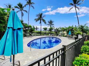 una piscina con due ombrelloni accanto a una recinzione di Maui Eldorado Condo K212 a Kaanapali
