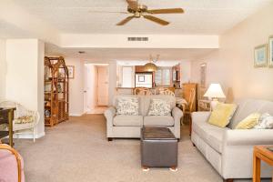 a living room with two couches and a ceiling fan at Pier Point South Ocean View Condo B-22 in Saint Augustine Beach