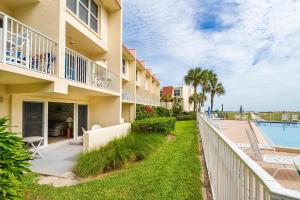 an apartment building with a pool and a fence at Pier Point South Ocean View Condo B-22 in Saint Augustine Beach +5 photos