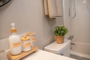 a bathroom with a toilet and a bottle of soap at Stylish & Cozy Retreat with Backyard & Parking in Charlotte +35 photos