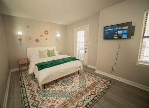 a bedroom with a bed and a tv on the wall at Stylish & Cozy Retreat with Backyard & Parking in Charlotte