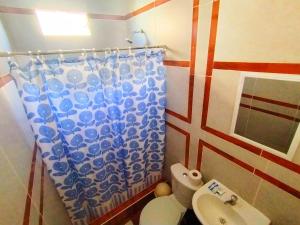 a bathroom with a toilet and a shower curtain at HOSPEDAJE WELCOME PARACAS peru in Paracas
