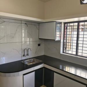 una cucina con un lavello e un piano di lavoro di Aromal Homestay a Trivandrum Altre 8 foto