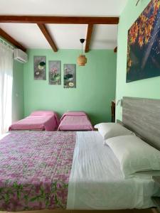 a bedroom with two beds with pink cushions at Casa Vacanza Finalmente in SantʼAngelo le Fratte