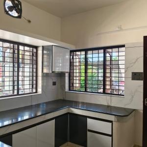 una grande cucina con finestre e piano di lavoro di Aromal Homestay a Trivandrum