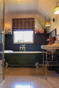 a green bath tub in a room with a window at 100 year old family farmhouse in Oldcastle