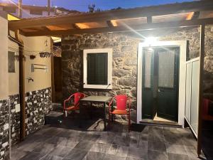 a patio with a table and two red chairs at Mocha Studio in Machico