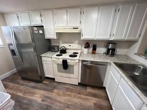 a kitchen with white cabinets and stainless steel appliances at Pier Point South Oceanfront Townhouse Condo E-63 in Saint Augustine Beach