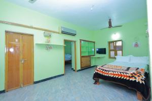 a bedroom with a bed and a tv in a room at MSN Homestay in Srikalahasti