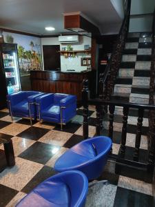 un bar con sedie blu su un pavimento a scacchi di Hotel COP 30 a Belém