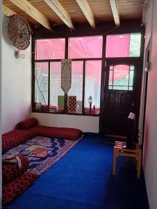 Una sala de estar con un sofá y una ventana. en Cottage De Hunza- A Soul Retreat Sanctuary, en Hunza