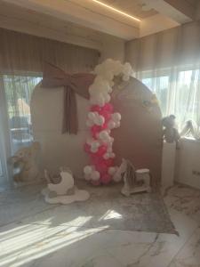 a room with a bed with balloons and stuffed animals at Baltasis beržas 