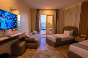 a hotel room with two beds and a flat screen tv at Elevana Boutique hotel in Cairo