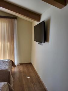 a bedroom with a flat screen tv on the wall at Pirin Golf Villa Sokol in Bansko