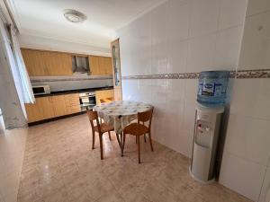 a kitchen with a table and chairs in a room at Alojamiento Ines in Sanxenxo