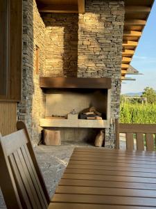 a stone fireplace with a wooden table and a bench at Pirin Golf Villa Sokol in Bansko