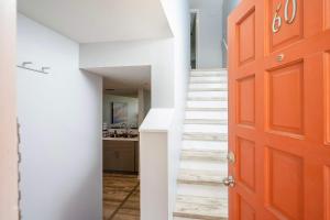 une porte orange dans un couloir avec un escalier dans l'établissement Pier Point South Oceanfront Townhouse Condo E-60, à Saint Augustine Beach