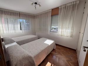 a bedroom with two beds and a window at Alojamiento Ines in Sanxenxo +7 photos
