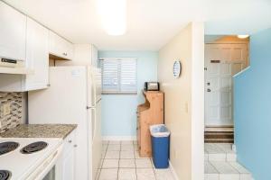 a kitchen with white cabinets and a refrigerator at Pier Point South Ocean View Condo B-18 in Saint Augustine Beach