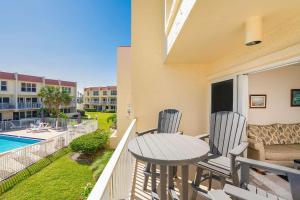 a balcony with a table and chairs and a pool at Pier Point South Ocean View Condo B-18 in St. Augustine
