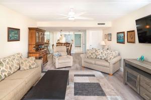 a living room with couches and a flat screen tv at Pier Point South Ocean View Condo B-18 in St. Augustine