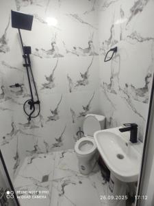 un baño con inodoro y lavabo en Kamila-House, en Urganch