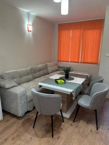 a living room with a couch and a table and chairs at Апартамент Мони in Veliko Tŭrnovo