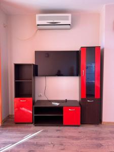 a room with a bed with red and black cabinets at Апартамент Мони in Veliko Tŭrnovo