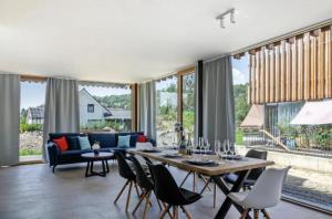 a living room with a table and chairs and a couch at Penthouse Panorama Deluxe - Seesicht - BBQ - Beach Paradise - Loft Premium in Öhningen