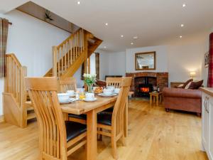 a kitchen and living room with a wooden table and chairs at The Old Laundry - Uk12136 in Hewelsfield