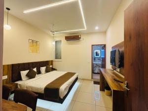 a hotel room with a bed and a television at Hotel Ramayan Inn in Rishīkesh