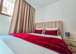 Un dormitorio con una cama con una manta roja encima. en Luxury Renovated Apartment in Agadir, en Agadir