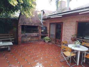 a brick patio with a table and a grill at Vila Bela in Tigre