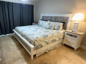 a bedroom with a bed and a night stand with a lamp at Pier Point South Oceanfront Condo A-1 in Saint Augustine Beach +5 photos