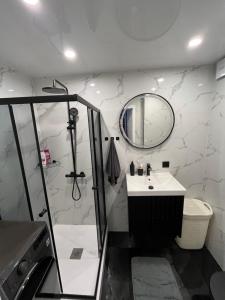 een badkamer met douche, wastafel en spiegel bij Fabulous Central Apartment in Daugavpils