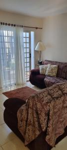 a living room with a bed and a couch at Casa com ampla área de lazer há 10 minutos do Santuário de Aparecida in Guaratinguetá